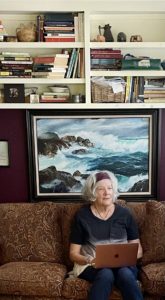 Photo of Kathleen at work in her small office. Behind her is a painting by her father, who took up oil painting after retirement, immersing himself in it much as Kathleen has immersed herself in writing. Photo: Don Anderson